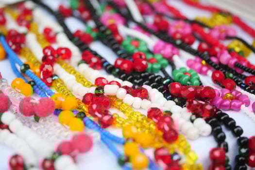 Colorful bead necklaces displayed at a local market in summer sunlight photo