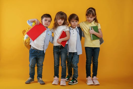 Notepads in hands,, conception of education. Kids are together against yellow background photo