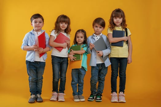Standing and posing. Kids ,are together against yellow background photo