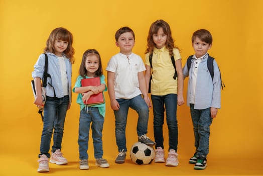 Standing ,and posing... Kids are together against yellow background photo
