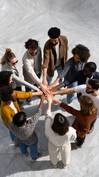 Diverse group hands clasped in circle, united photo