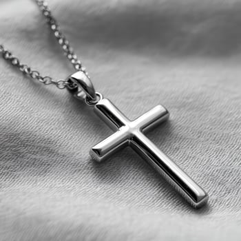 A silver cross necklace on a bed photo