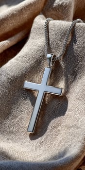 A silver cross pendant on a linen cloth photo