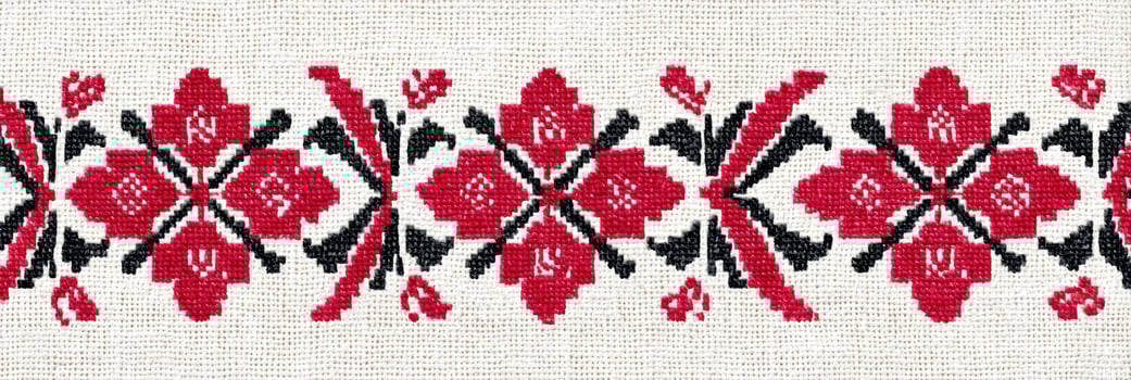 Ukrainian cross-stitch embroidery pattern featuring intricate floral designs in vibrant red and black threads on a light fabric background, showcasing traditional craftsmanship and cultural artistry photo