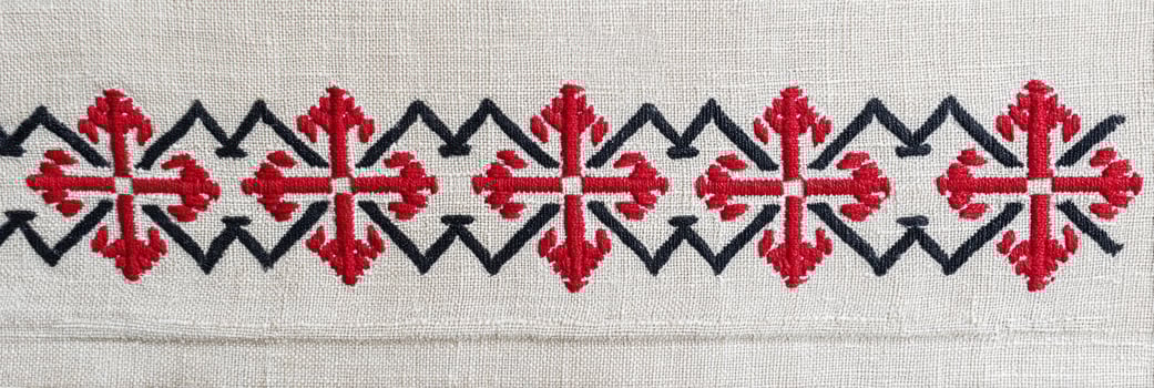 Romanian traditional embroidery featuring intricate red and black patterns on a natural fabric background, showcasing cultural artistry and craftsmanship in textile design photo