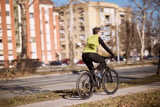 Midle Age Woman Riding Bike Down Street photo