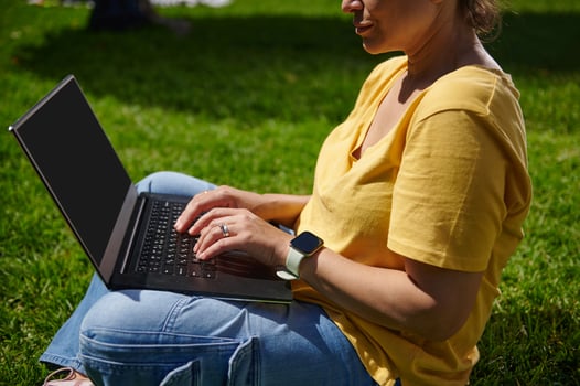 Woman Using Laptop Outdoors Sitting on Grass in the Park photo