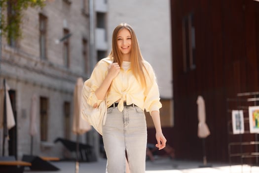 Woman in casual outfit enjoying a sunny day while walking through a charming urban area with art displays photo