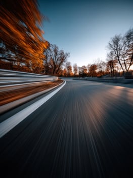 Curved road with vibrant autumn trees at dusk photo