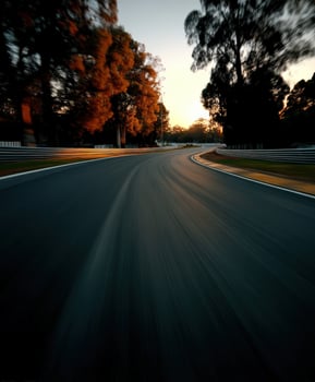 Racing along a winding road surrounded by trees at sunset photo