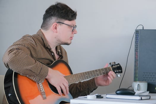 Young man musician playing classical guitar at home photo