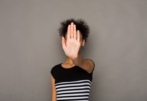 Young african-american woman covering her face with palm saying no. Girl denying proposal, making stop gesture with her hand. Studio shot, copy space photo