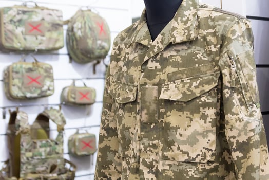 Mannequin dressed in camouflage attire and tactical gear on display in military store photo