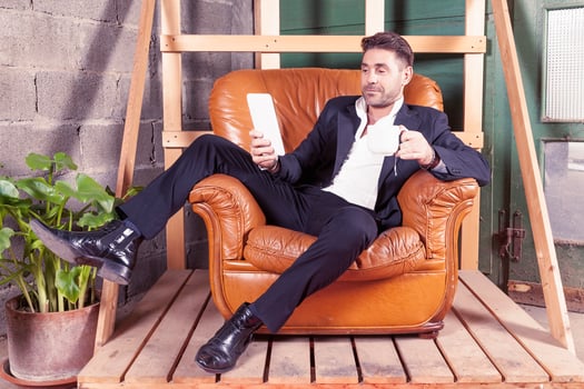 young businessman sitting in his chair in the new office using a tablet photo