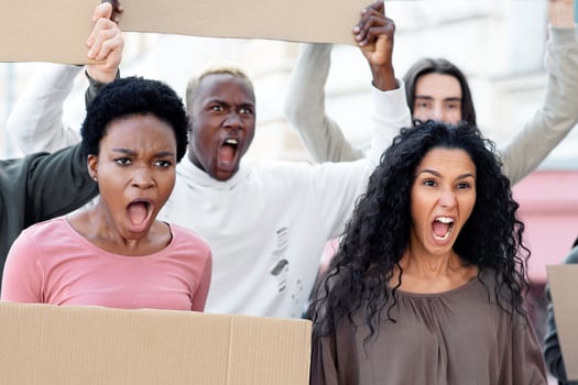 International group of activists young men and women holding empty banners and chanting slogans on the street, closeup. Furious demonstrators making strike against racism, pollution, war photo