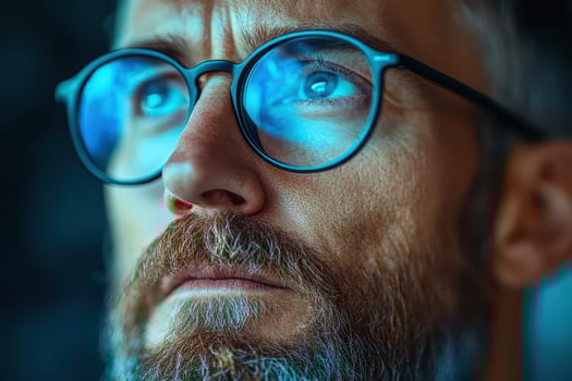 Man with glasses gazes thoughtfully in close up photo