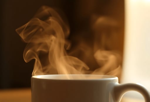 steaming cup of coffee on a table photo
