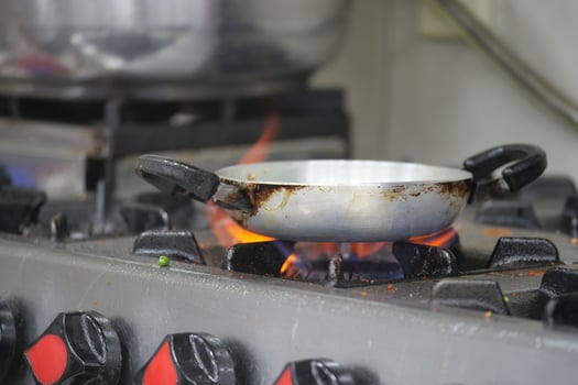 Cooking process on gas stove with pan over open flame photo
