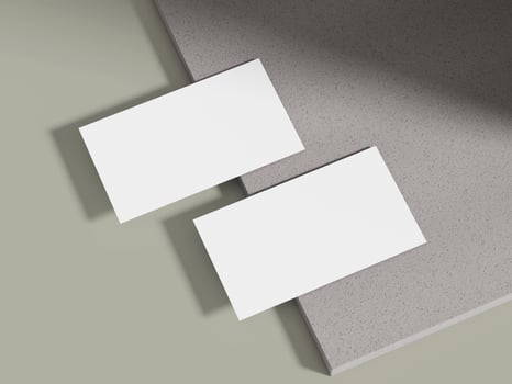 A business card mockup leaning on a muted grey cement block with soft lighting, ideal for luxury brand displays. photo