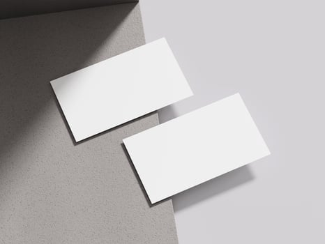 Business card resting on a light taupe cement block, offering a neutral and elegant presentation for design portfolios. photo