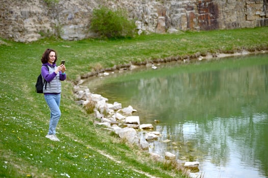 A woman tourist making photo of lake in Skrylle naturreservat Lund Skane Sweden