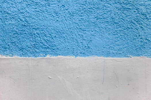 A wall with a blue and white stripe. The blue stripe is painted on top of the white. photo
