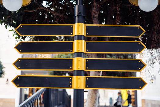 Directional signpost with multiple blank arrows in an urban setting during daylight hours. photo
