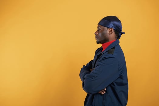 View from, the side. Handsome black man is in the studio against yellow background photo