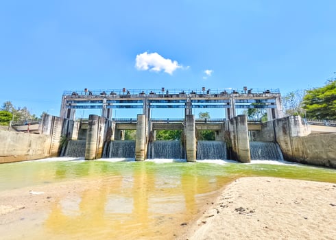 Scenic View of a Modern Dam with Clear Blue Sky and Flowing Water in a Natural Setting photo