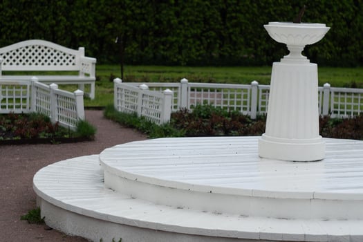 White garden sundial and bench in peaceful park setting photo