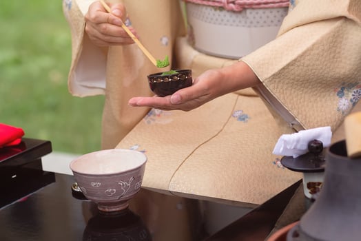 Woman in kimono performs Japanese tea ceremony photo