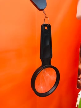 Magnifying glass displayed on bright orange background. photo
