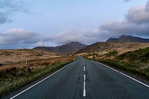 Serene Road Leading to Mountain Peaks at Dusk photo