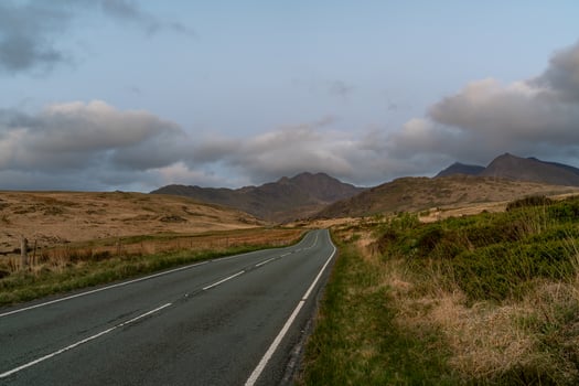 Scenic Road Leading to Snowdonia Mountains at Dusk photo