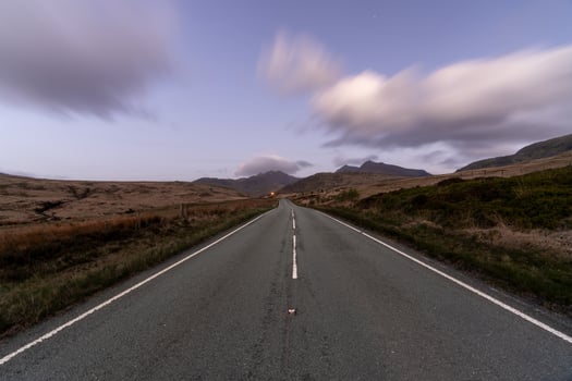 Serene Road Leading to Distant Mountains at Dusk photo