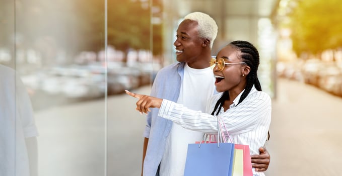 Something new. Surprised african american couple saw sale in shop showcase, free space photo