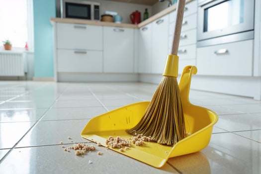 A yellow broom and dustpan on a tiled floor photo