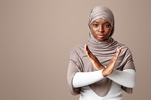 Say No To No Racism. Serious Black Muslim Woman In Hijab Showing Cross Hands Gesture, Demonstrating Denial Sign, Rejecting Something Unwanted, Posing Over Light Studio Background, Copy Space photo