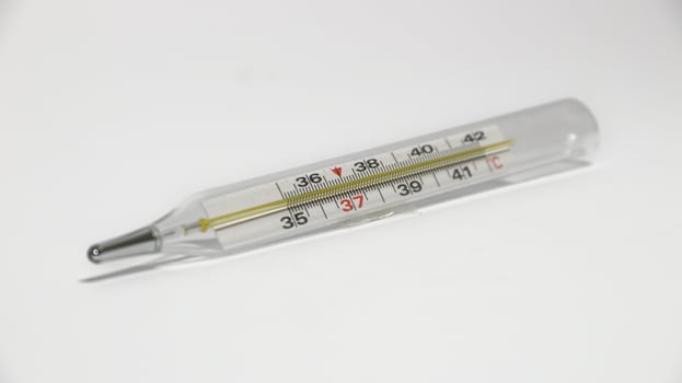 Close-up shot of clinical thermometer on white surface. photo