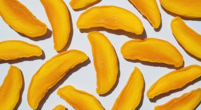 Delicious slices of dried mango arranged on a clean white surface photo