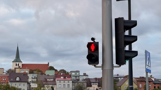 Urban neighborhood with red traffic light signalized urban cityscape featuring residential roofs and overcast sky in autumn season photo
