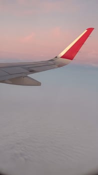 Airplane wing in serenity, red-tipped aircraft wing against a tranquil sunset and cloudscape photo