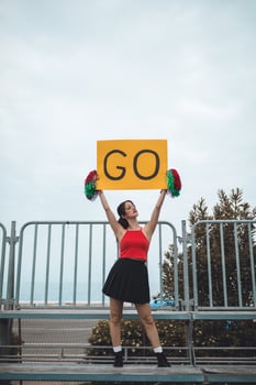 Young Women Cheers Her Heart Basketball Team On The Stands photo