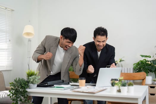 Celebration and Success. Two professionals celebrating a significant achievement in their modern office environment. photo