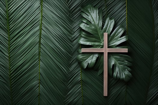 Wooden christian cross resting on tropical leaves symbolizing faith and nature photo