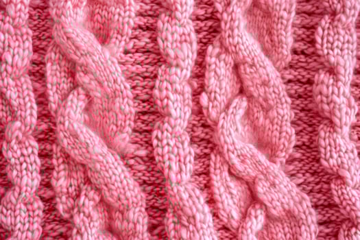 Cable knit pink wool texture creating cozy and warm background photo