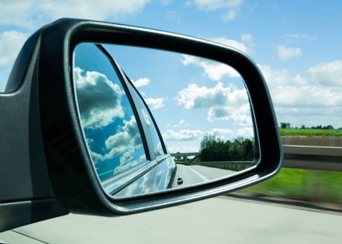 Road and clouds reflected in car side mirror photo