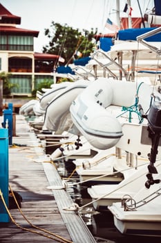 Sailboats moored at marina with inflatable dinghies, nautical theme, background photo