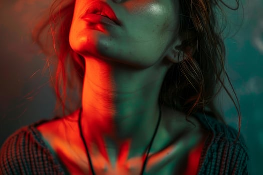 Fashion model posing with red and green lights illuminating neck and face photo