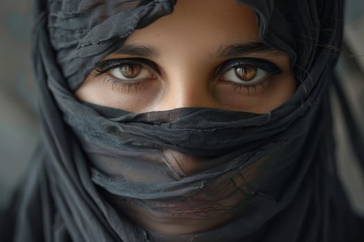 Muslim woman wearing black niqab and showing expressive brown eyes photo